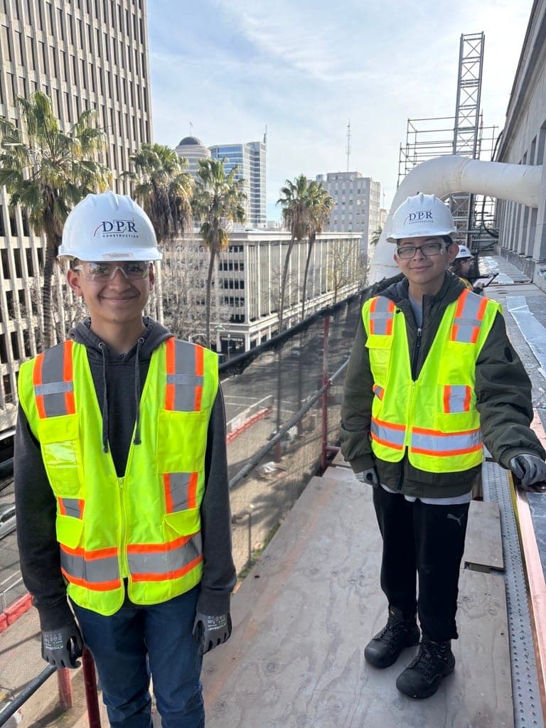 Student interns in safety gear at a construction job site