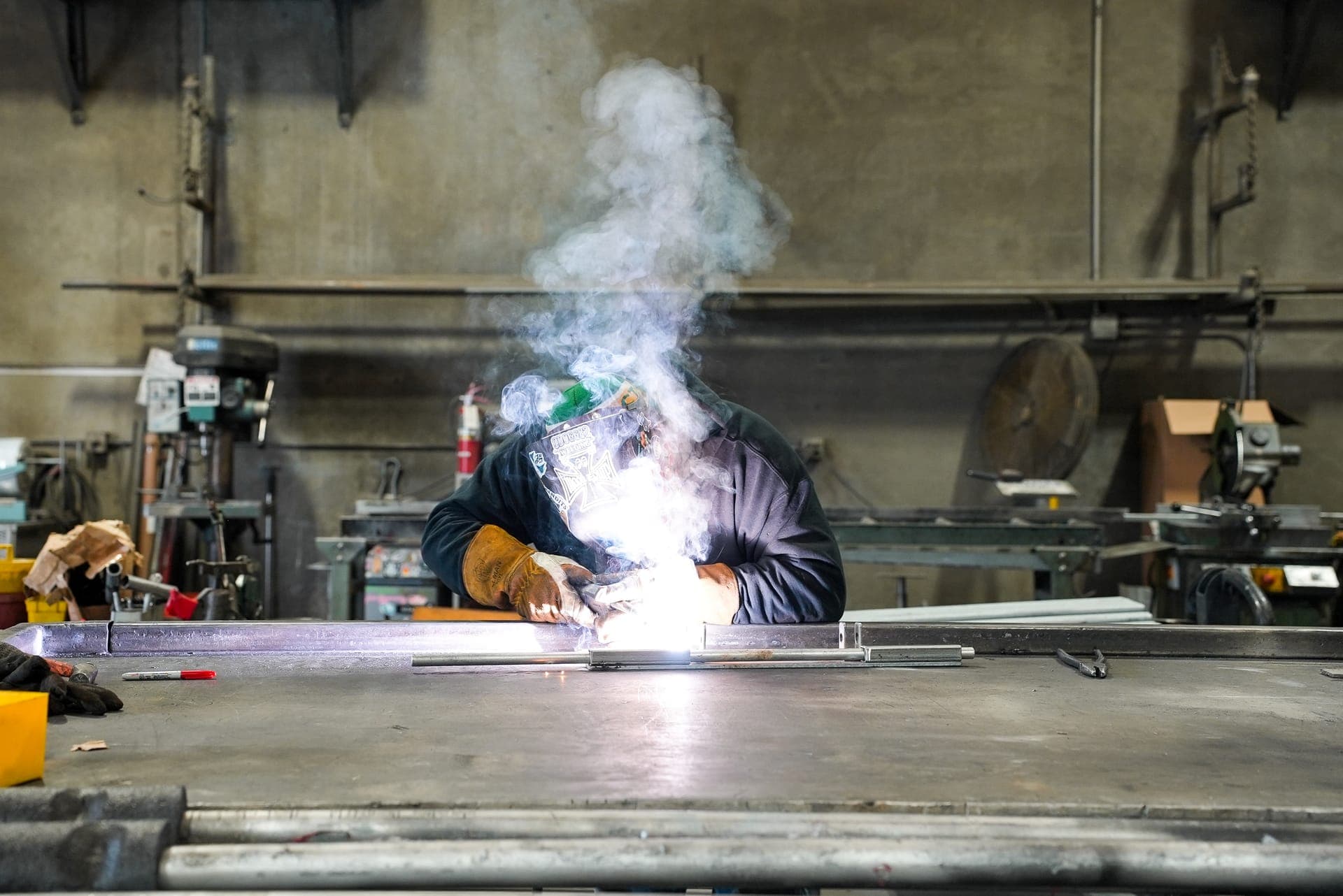 A student welding in a fabrication shop